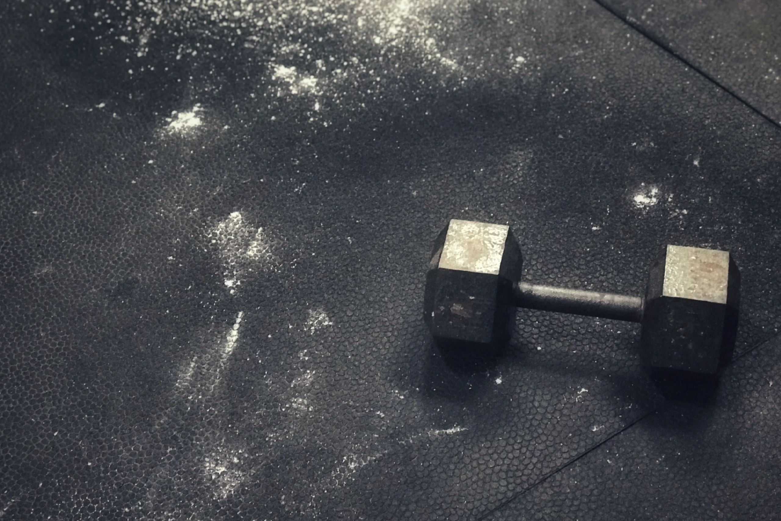 Dumbbell on gym floor with chalk